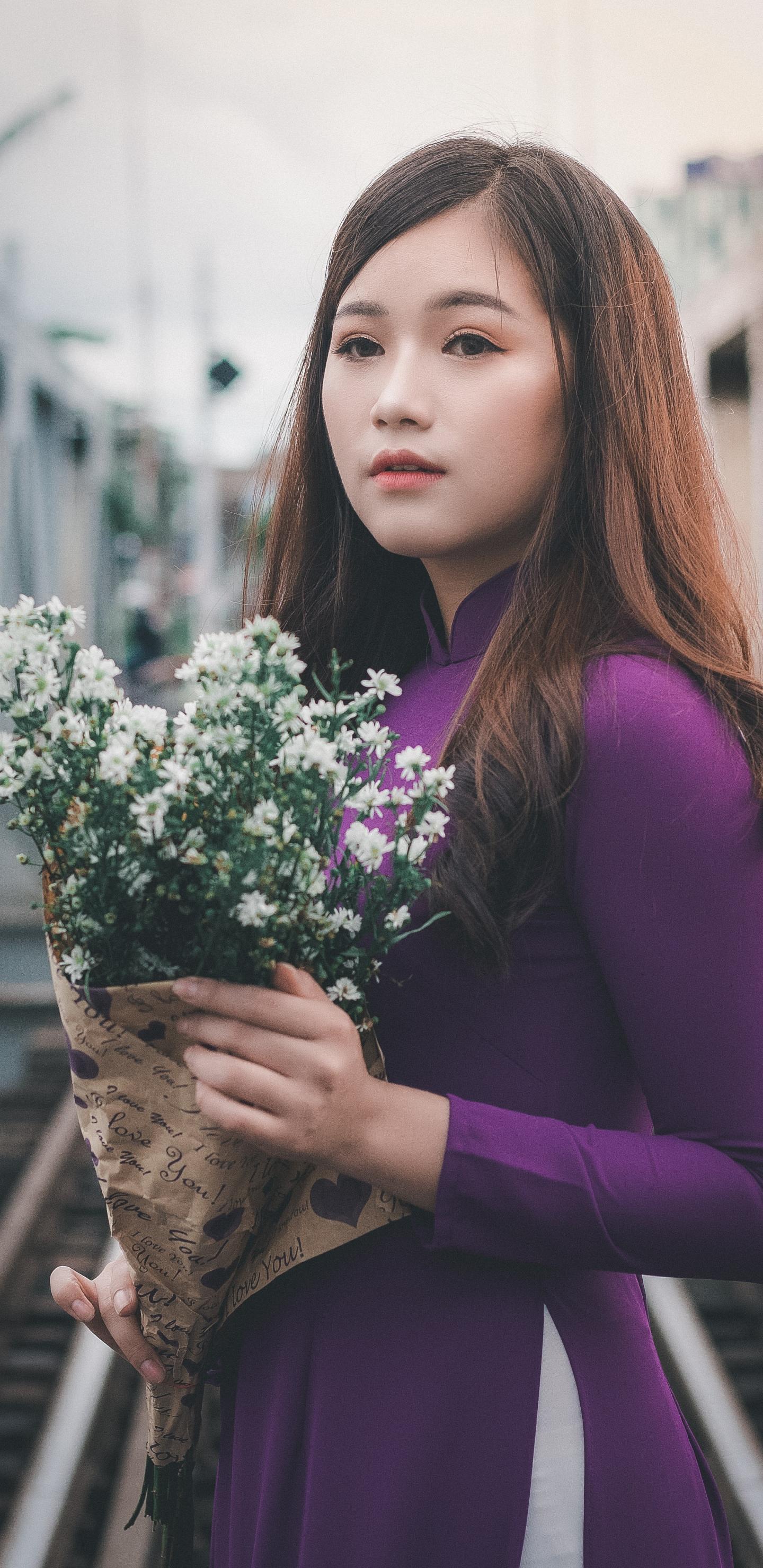 拿着白色野菊花的美女