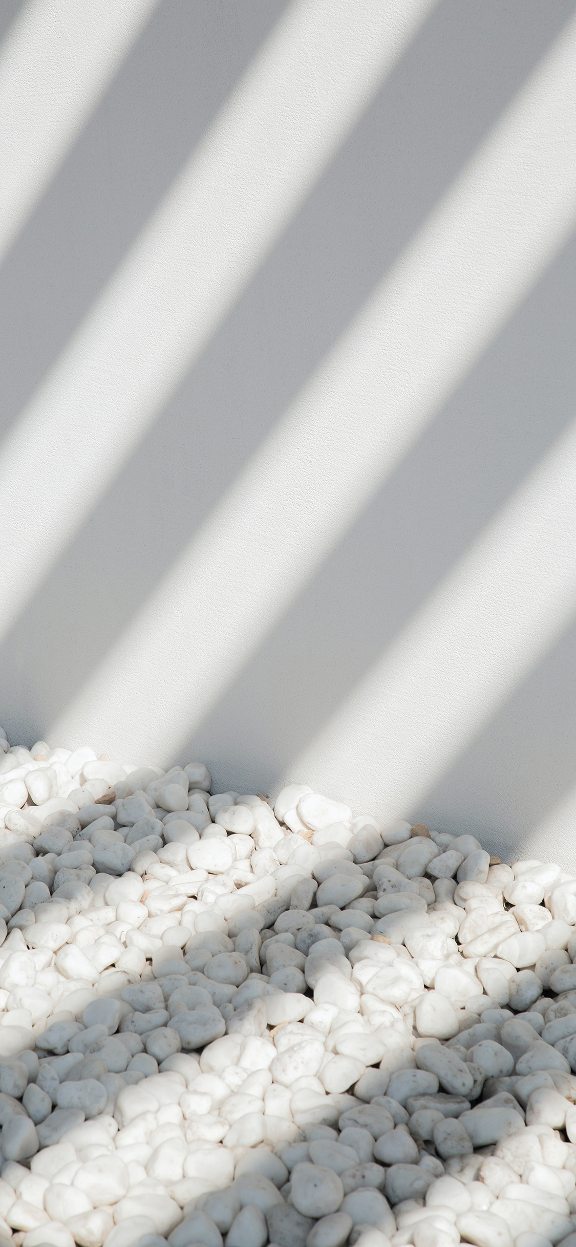 [2436×1125]墙角 阳光 投影 鹅卵石 白色 苹果手机壁纸图片