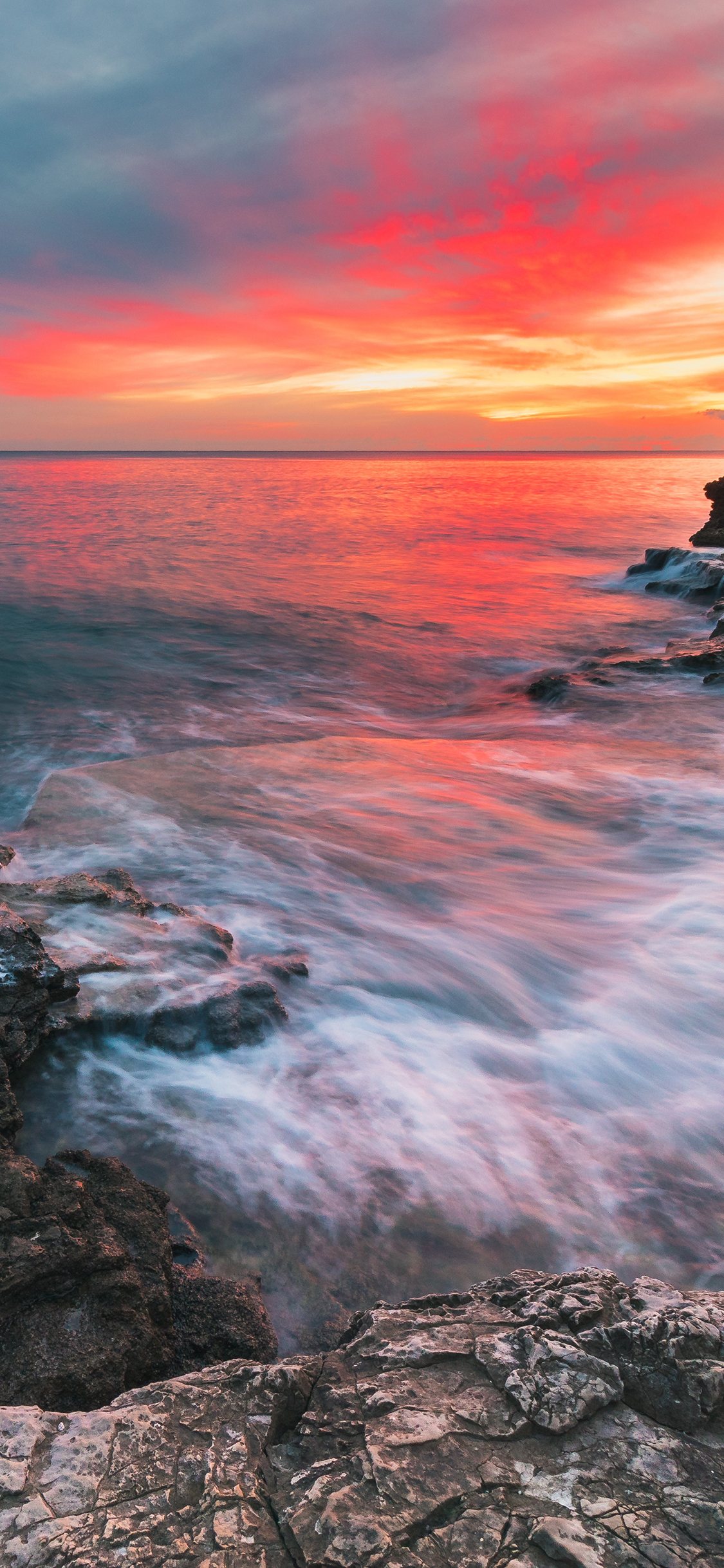 [2436×1125]夕阳 礁石 海水 汇入 苹果手机壁纸图片