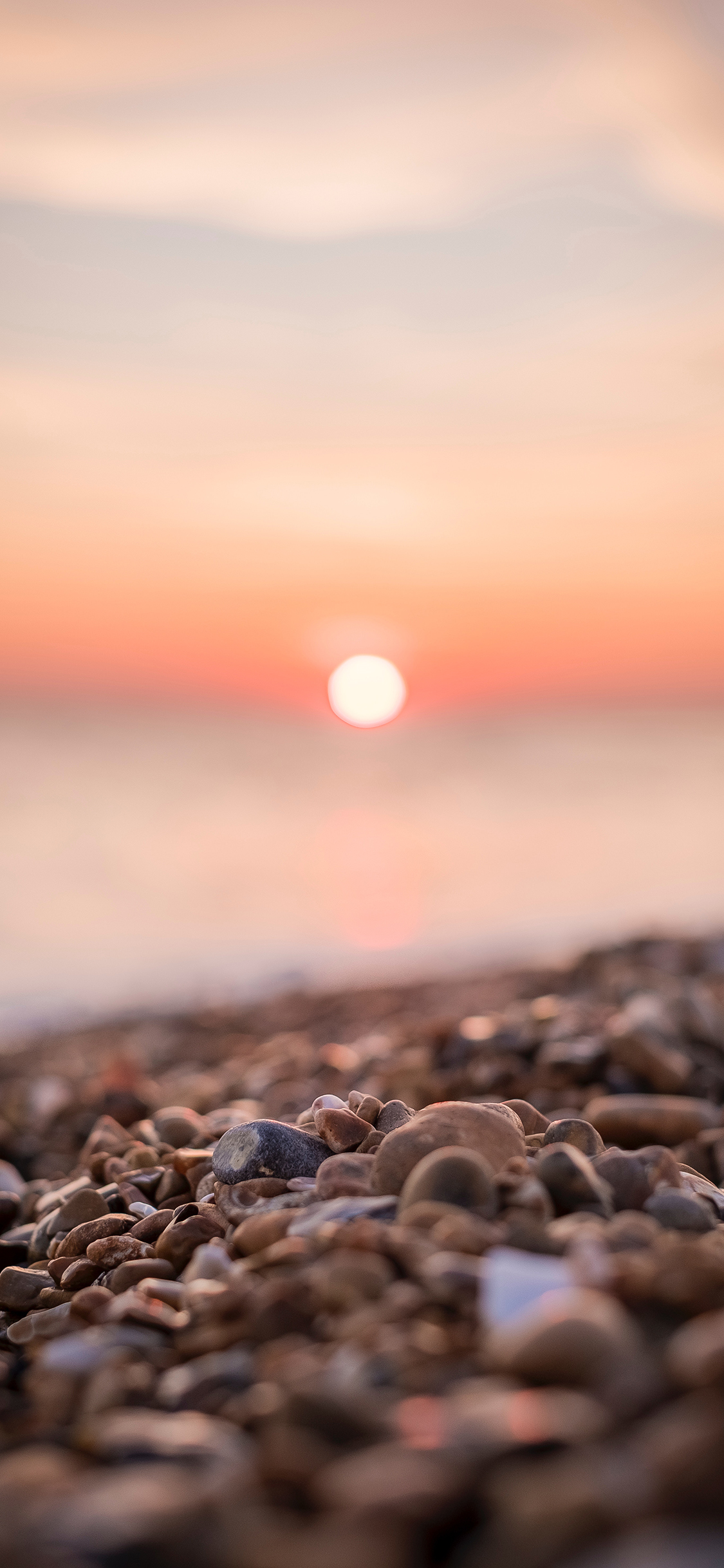 [2436×1125]夕阳 落日 石头 石滩 苹果手机壁纸图片