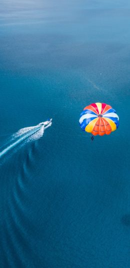 [2436x1125]大海 船只 快艇 降落伞 苹果手机壁纸图片