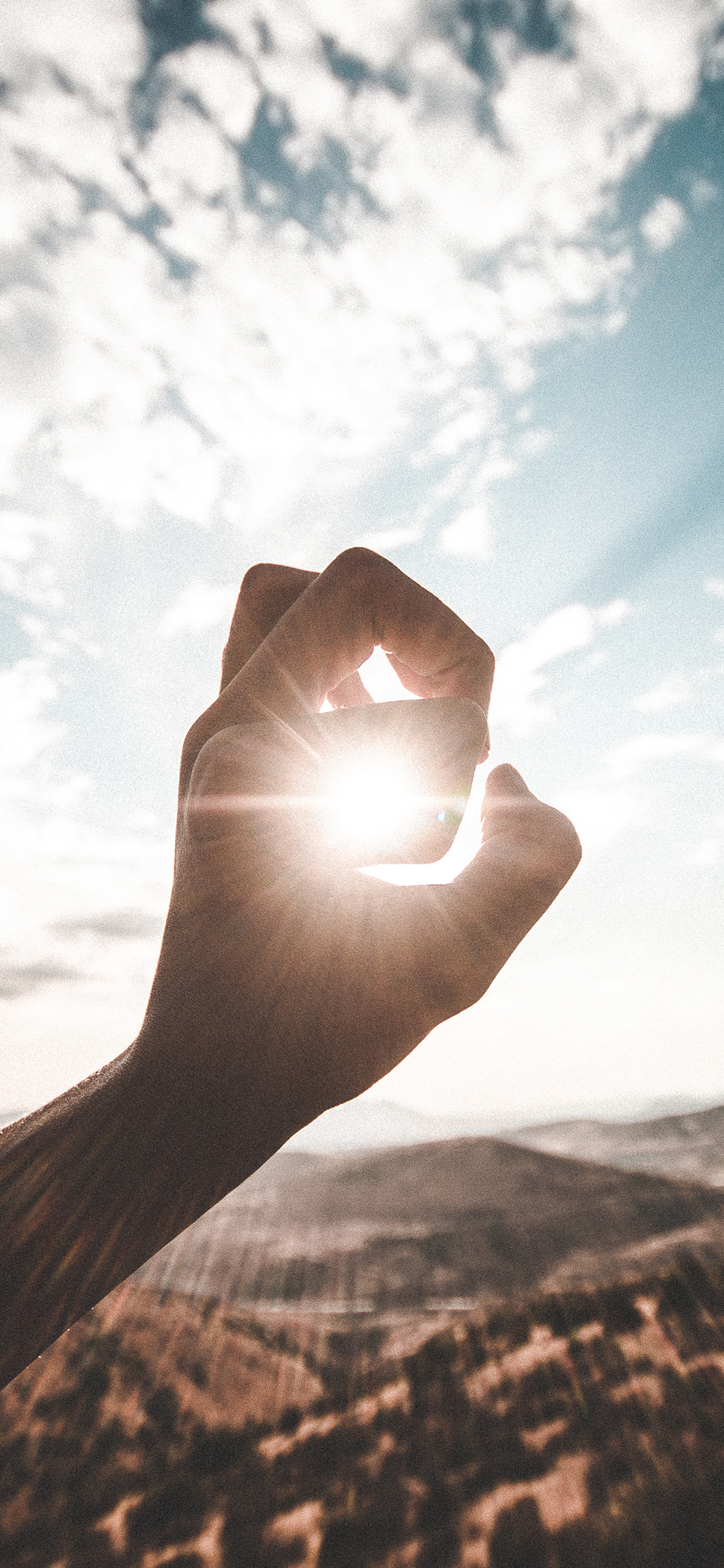 [2436×1125]山峰 蓝天白云 阳光 手 苹果手机壁纸图片