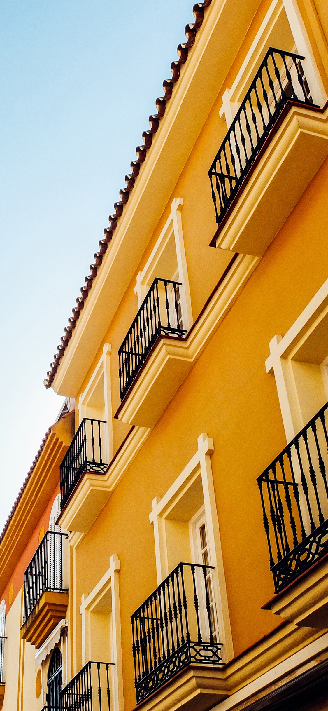 [2436×1125]旅店 城市 住宅 建筑 黄色 窗 阳台 苹果手机壁纸图片