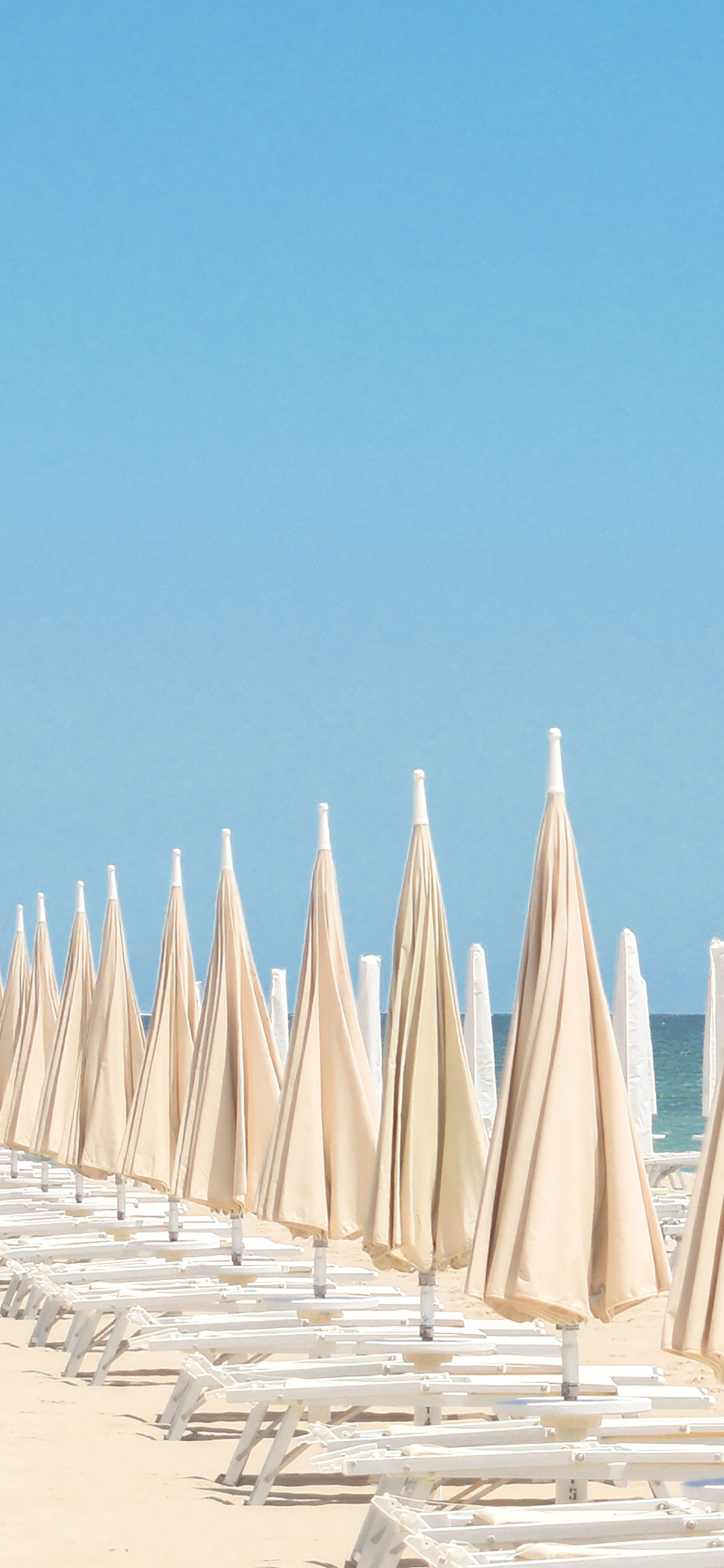 [2436×1125]沙滩 躺椅 太阳伞 度假 天空 蔚蓝 苹果手机壁纸图片