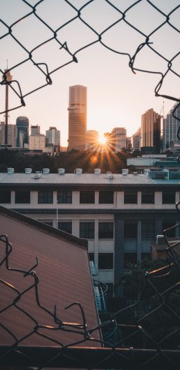 [2436x1125]铁丝网 建筑 城市 日出 苹果手机壁纸图片